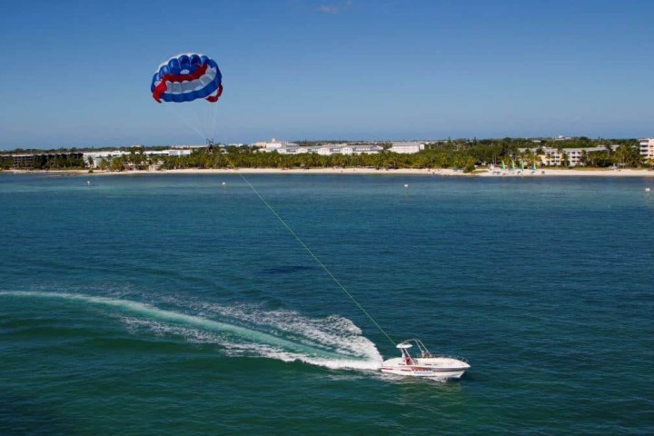 a man flying a kite in a large body of water